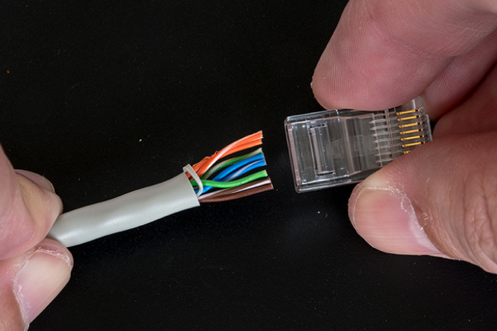 Example of an RJ45 plug being fitted to the end of and ethernet cable